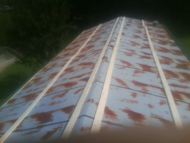 Rusted metal roof panels with new wood purlins before replacement — Storm Damage Roof Repair in Skokie by Roofing Brothers