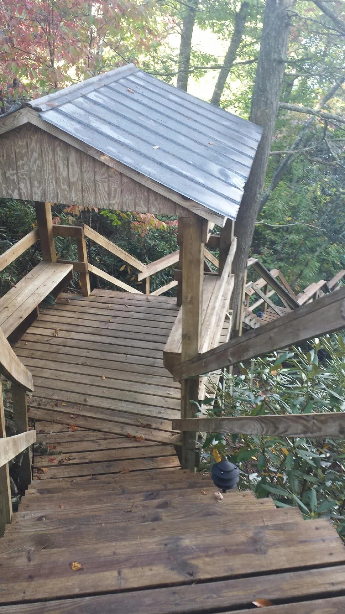 Metal roofed shelter over wooden steps on a wooded walkway — Skylight Repair & Installation work by our crew in Skokie